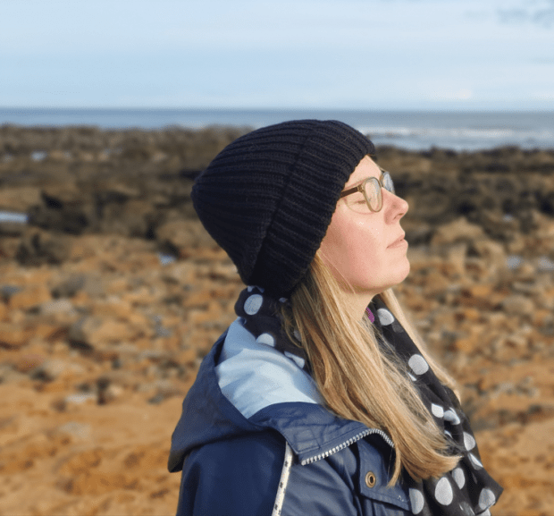 Writer Laura-Liisa Klaas on a beach enjoying sunshine